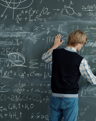 Student working through equations on a chalkboard